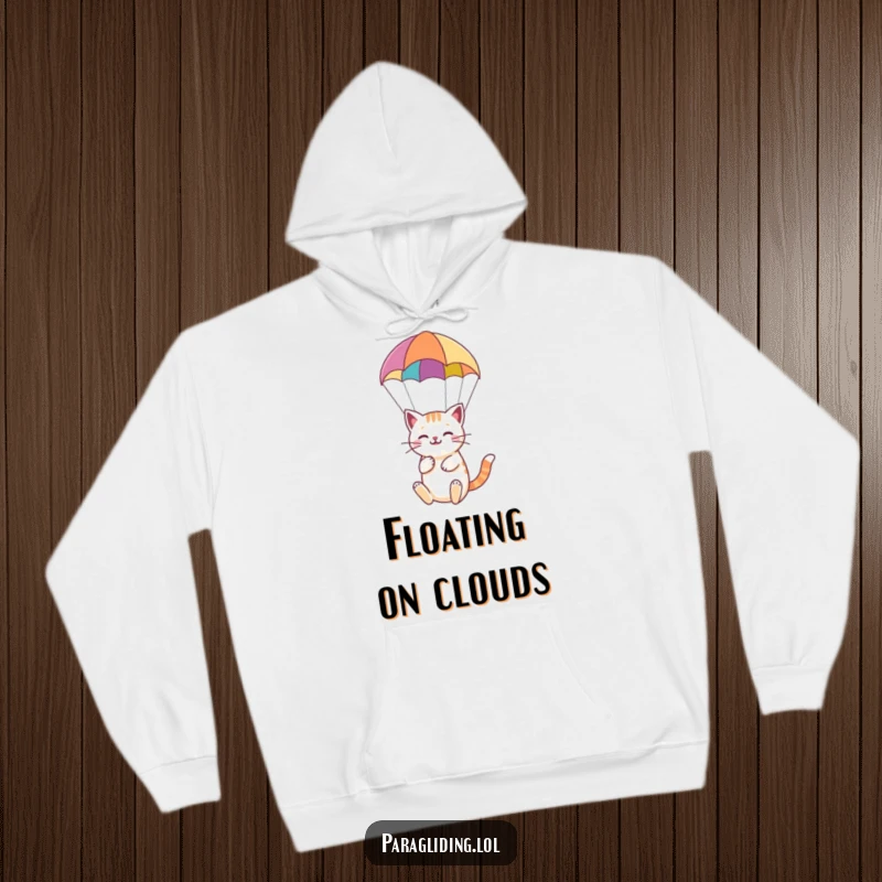 Funny hoodie featuring a happy cat serenely paragliding under a colorful parachute, offering cozy and peaceful vibes.