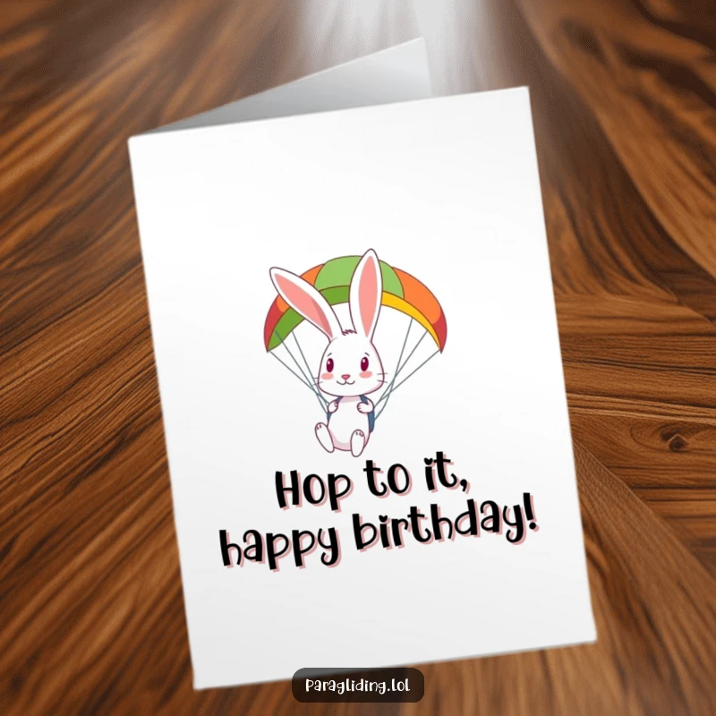 Funny Free Printable Birthday Card: a curious rabbit peeking down from a vibrant, colorful paraglider.